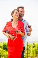 Smiling couple with wineglasses looking away