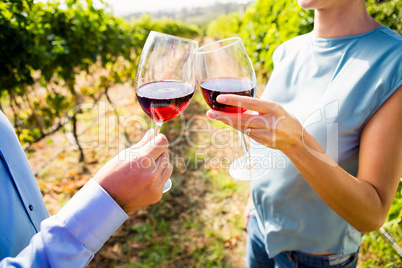 Midsection of couple toasting wineglasses