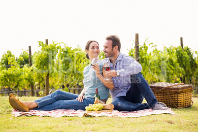 Smiling couple enjoying red wine at lawn
