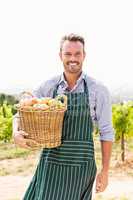 Portrait of man with apple basket at vineyard