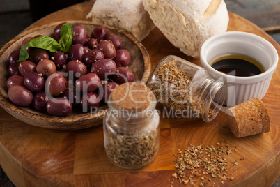 High angle view of spices by black olives in plate
