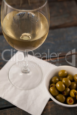 Close up of white wine by green olives served in container