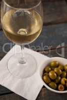 Close up of white wine by green olives served in container
