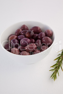 Close up of brown olives by herb