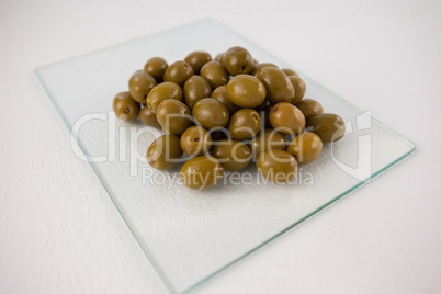 Close up of green olives on glass slab