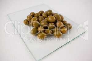 Close up of green olives on glass slab