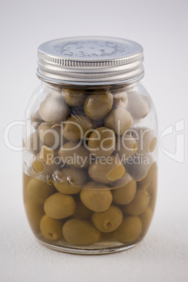 Close up of green olive in glass jar with lid