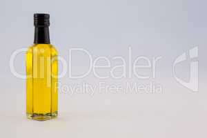 Yellow oil bottle against wall