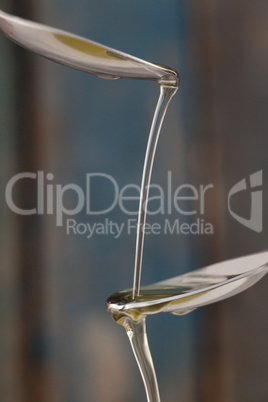 Olive oil pouring on spoon