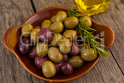 Close up of olives with rosemary in bowl
