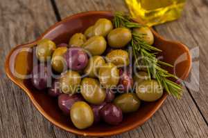 Close up of olives with rosemary in bowl