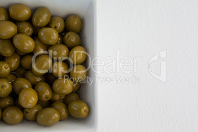 Overhead view of green olives in bowl