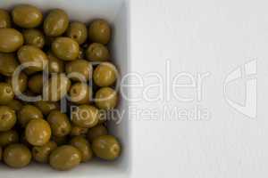 Overhead view of green olives in bowl