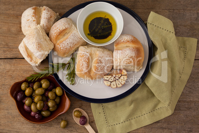 Overhead view of bread bread in plate by olives