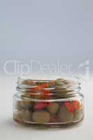 Close up of green olives and herbs in glass jar