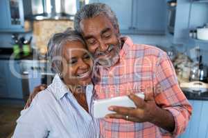 Smiling couple taking selfie at home