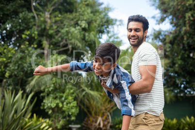 Playful father playing with son at yard