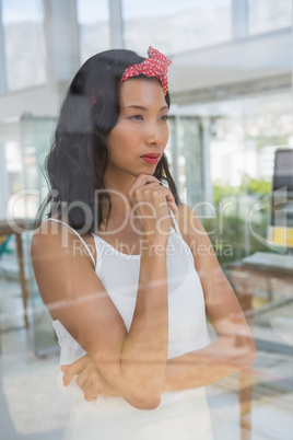 Thoughtful businesswoman at office seen through glass