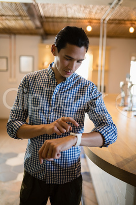 Man operating smartwatch at counter in restaurant