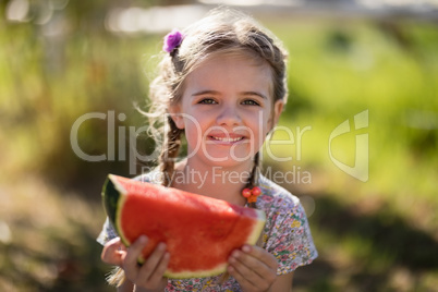 Cute girl having a watermelon slice in park