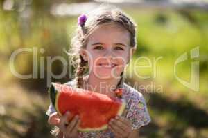 Cute girl having a watermelon slice in park