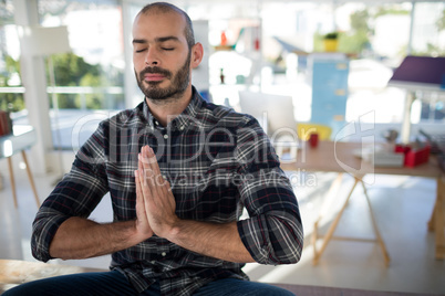 Male executive doing yoga in office