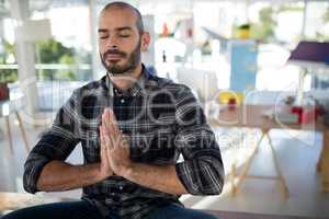 Male executive doing yoga in office