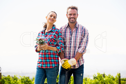 Portrait of smiling woman with man holding potted plant