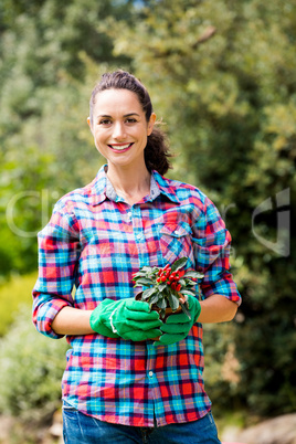 Portrait of woman with potted plant against trees