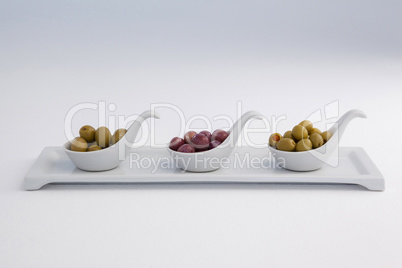 Various olives in container on white background