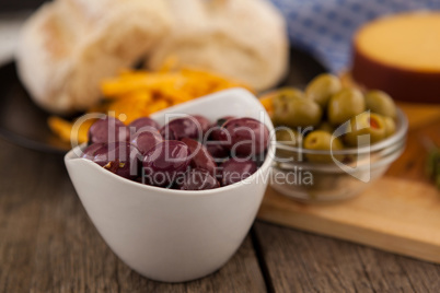 Olives in bowl by cutting board