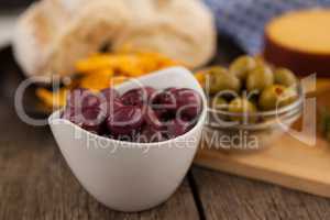 Olives in bowl by cutting board