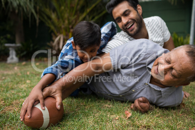 Happy family playing american football in yard