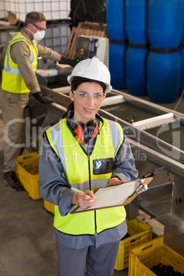 Technicians writing in clipboard