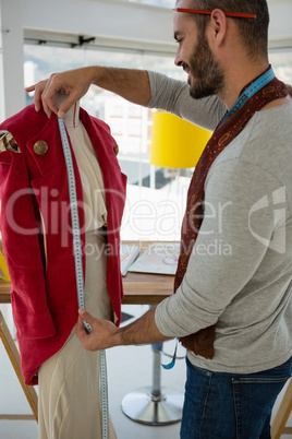 Designer measuring jacket on mannequin