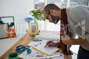 Male designer drawing sketch while standing at table