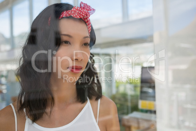 Thoughtful businesswoman at studio seen through glass