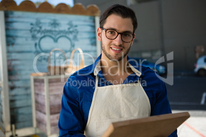 Portrait of smiling owner holding writing slate by food truck