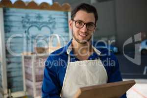 Portrait of smiling owner holding writing slate by food truck