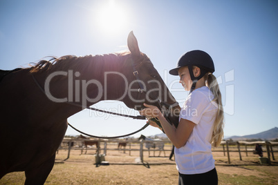 Rider girl caressing a horse in the ranch