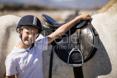 Smiling rider standing with his hand on white horse
