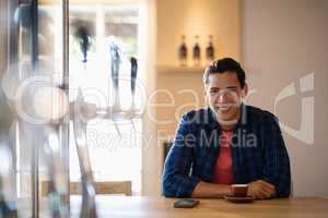 Smiling man having coffee in restaurant