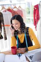 Female designer talking on mobile phone in office