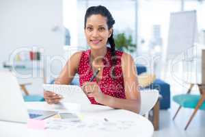 Female graphic designer using graphic tablet at desk