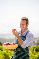 Smiling young man looking at apple