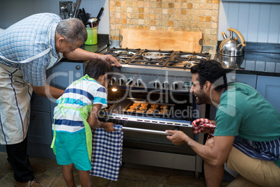 Family keeping cookies in oven