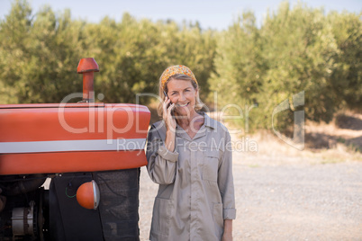 Portrait of happy woman talking on mobile phone in olive farm