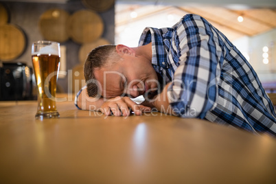Drunken man sleeping on bar counter