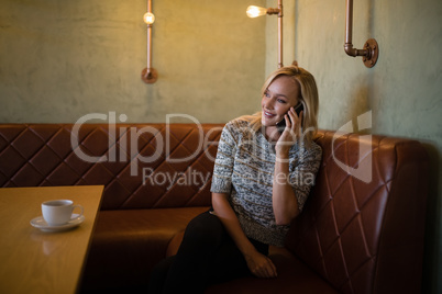 Beautiful woman talking on mobile phone in restaurant