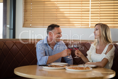 Happy couple toasting wine glass while having meal